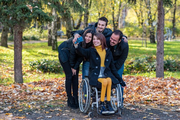 young-disabled-woman-wheelchair-taking-selfie-with-friends-park_936043-1554